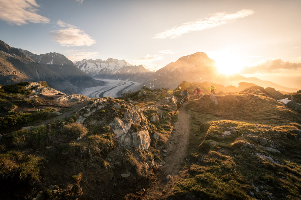 Roland Stauder und zwei Mountainbier/Finisher biken den Stoneman Glaciara am Großen Aletschgletscher im Wallis in der Schweiz während ihres MTB-Urlaubs.